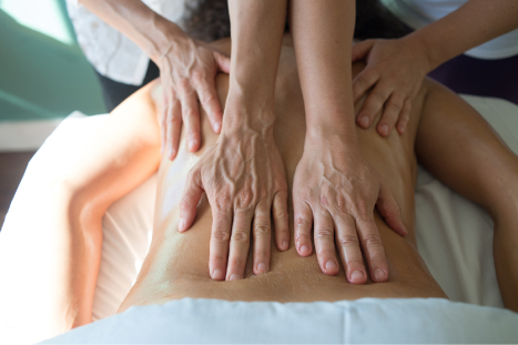 Abhyanga ~ Ayurvedic Massage - four hands massaging a persons back. 